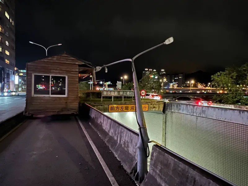 ▲拖吊車駕駛誤判道路寬，未注意到小木屋寬度比路寬，不慎撞歪路旁燈桿。（圖／警方提供）