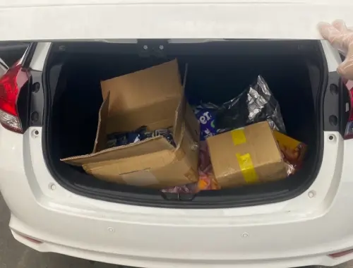 ▲員警叫醒在車內睡著的駕駛，發現駕駛座旁置物槽有一小罐愷他命毒品，後車廂內還有813包毒品咖啡包和毒品梅餅2顆。（圖／警方提供）