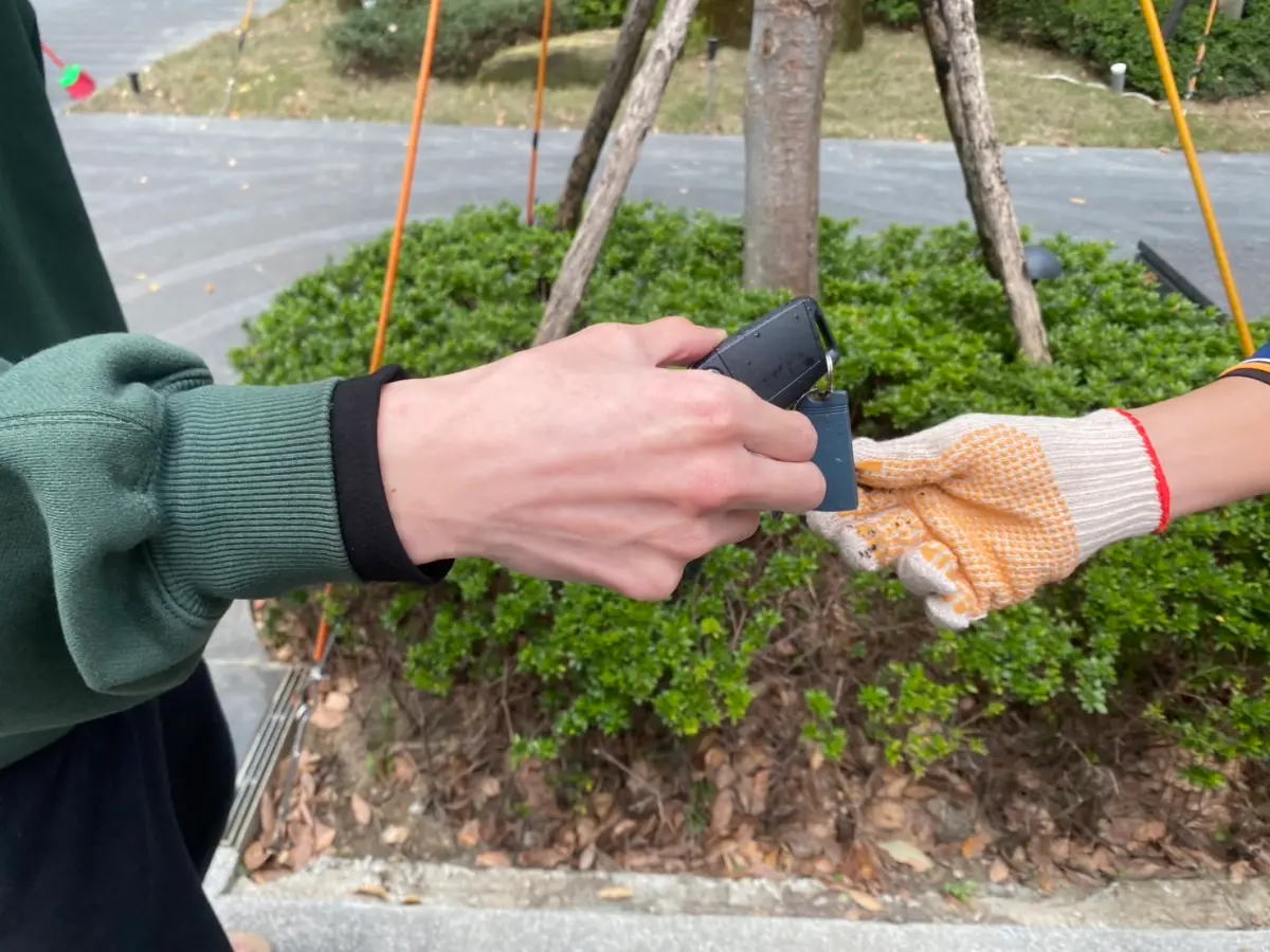 ▲新北板橋吳先生的汽車鑰匙掉進水溝蓋圓孔裡撿不出來，他急中生智求助清潔隊，1分鐘就解除危機，省下上萬元重打車鑰匙的費用。（圖／新北市環保局提供）