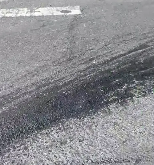 ▲台北市南港路一段突然出現大片黑色油漬，導致多名騎士行經此處，都發生滑倒摔車意外。（圖／讀者提供）