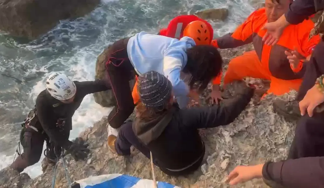 ▲高雄柴山有女遊客在礁石平台約9公尺處受困，警消協力救援所幸無大礙。（圖／警方提供）