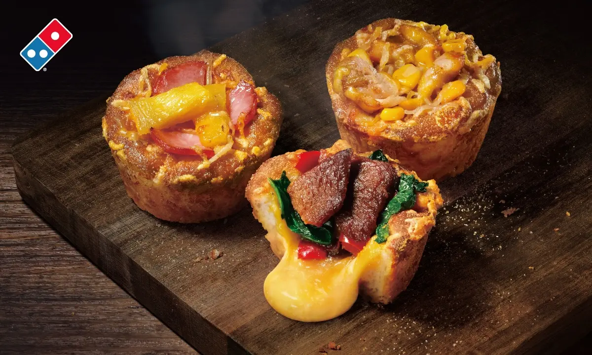 ▲達美樂很會！改Logo「骰到66」挺中華隊沸騰全台，起司火山披薩太夯、再開賣全新型態「熔岩披薩馬芬」，一人獨享濃郁起司爆漿。必勝客回歸「超濃五重起司披薩」，結合美國最受歡迎的「火辣蜂蜜」迎戰。（圖／達美樂提供）