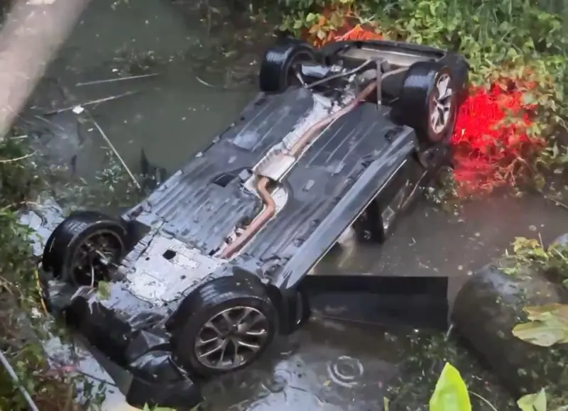 ▲賴姓駕駛開著BMW休旅車，疑似因天雨路滑失控，導致整輛車掉下一層樓高的大排水溝。（圖／翻攝畫面）
