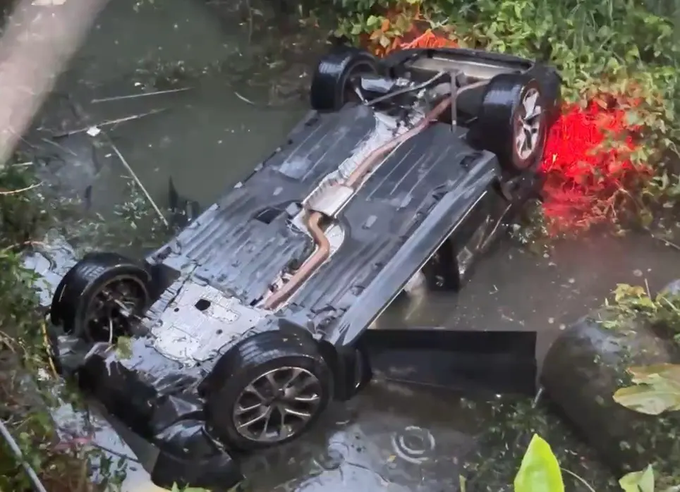 ▲賴姓駕駛開著BMW休旅車，疑似因天雨路滑失控，導致整輛車掉下一層樓高的大排水溝。（圖／翻攝畫面）