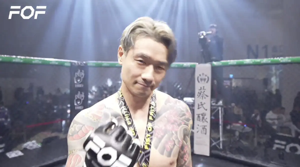 ▲今（8）日晚間第22屆《拳願明星格鬥賽》於高雄熱烈開打，壓軸戰局一開始，金鋼刀（如圖）進攻猛烈把李育昇揍到嘴巴含血模糊，裁判直接宣告金鋼刀勝出，引爆全場歡呼。（圖／翻攝自拳願官方直播）