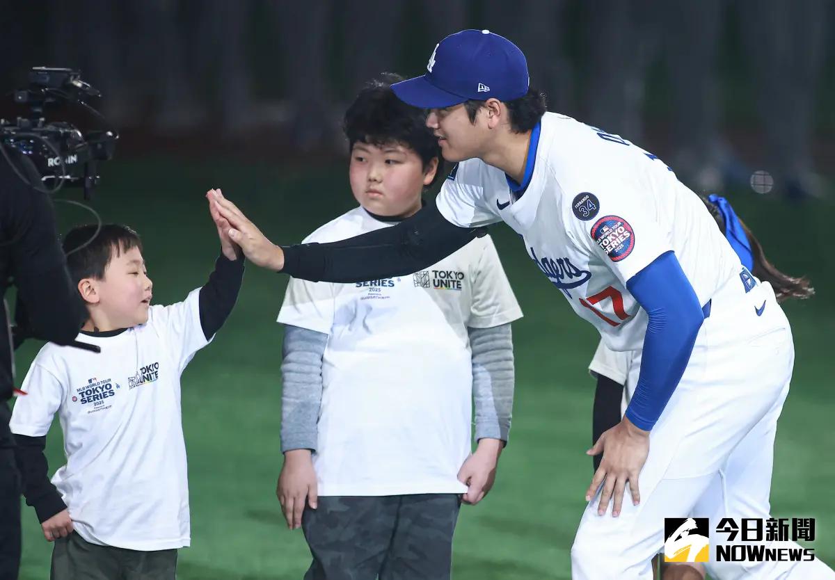 ▲大谷翔平在第五局轟出本季 首支全壘打，這顆彌足珍貴的全壘打球最終落入一名10歲日本小球迷水井颯良的手中，讓他開心表示：「我要把它當成傳家寶！」。圖為大谷翔平賽前儀式和小朋友擊掌，非當事人。（圖／記者葉政勳攝 , 2025.03.19）