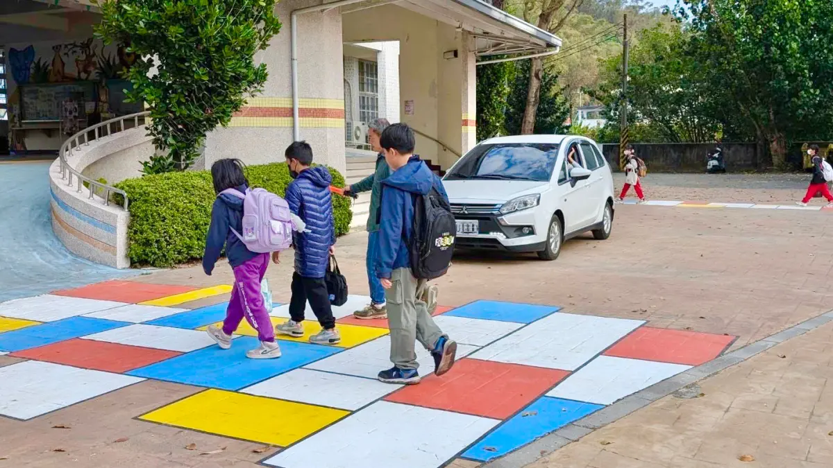 ▲旗山區溪州國小在校門內的兩條通學步道上，以「蒙德里安風格」進行彩繪，透過鮮明的色塊與線條設計，提高學童步行的注意力，達到人車注意停等且分流的目的。（圖／高市府教育局提供）