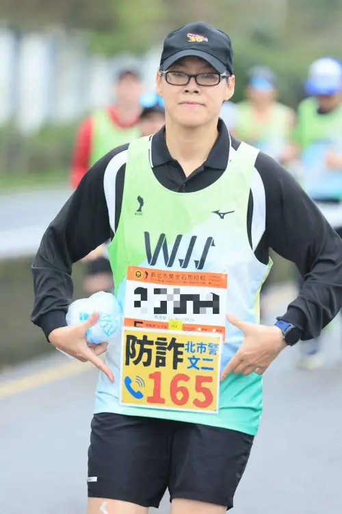 ▲台北市文山二分局警務員周洛安，日前參加「萬金石馬拉松」時，掛上自製的防詐標語，用另類方式宣導防詐觀念。（圖／警方提供）