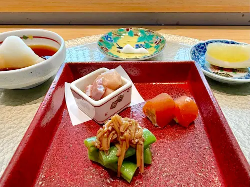 ▲上方以玉山為概念帶出小巧思的鹽巴，左側較細顆粒的是嘉義洲南鹽場冬天製作的霜鹽，右側偏粗的顆粒來自於法國鹽之花。「秋實冬語」前菜有油醋青魽、柿餅起司、胡麻時蔬。（圖／記者蕭涵云攝）