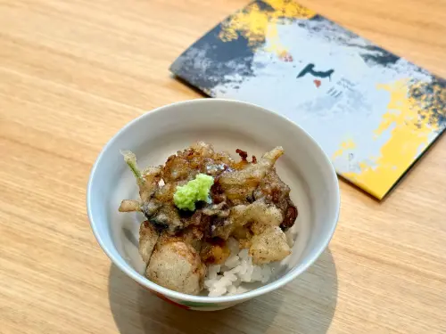 ▲「天婦羅丼飯」蓋著一片「蚵嗲」，選用澎湖老蚵、東石劍蝦與山芹菜打造。（圖／記者蕭涵云攝）