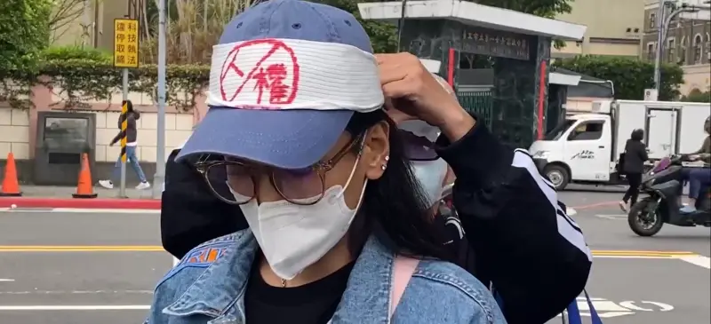 ▲小微為恩綺戴上白布條,抗議沒人權。(圖/記者劉松霖攝)