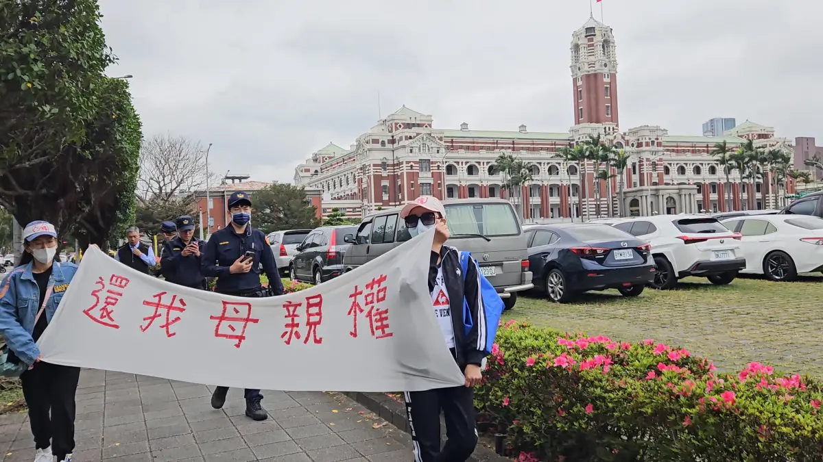 ▲涉及武統爭議的中配恩綺（左）、小微（右），到總統府陳情後拉布條。（圖／記者劉松霖攝）