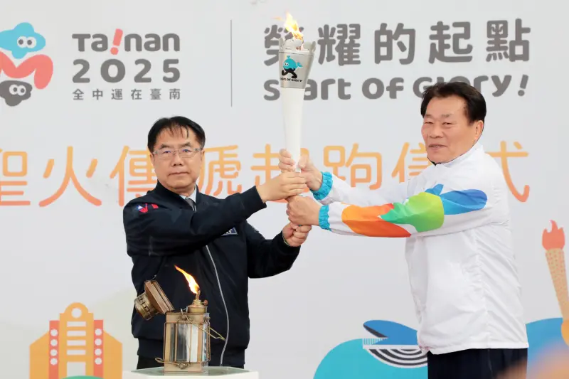▲全中運今天在主辦城市台南市政府舉辦本島聖火傳遞起跑儀式，市長黃偉哲（左）點燃聖火後交給體育局長陳良乾。（圖／南市府提供）