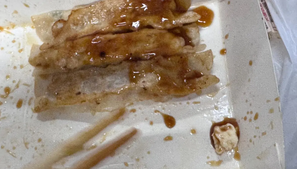 ▲桃園葉姓民眾昨（31）日在八方雲集平鎮某分店購買15顆鍋貼，結果快吃完時，才發現盒子底部竟黏著一塊疑被嚼過的口香糖。（圖／當事人授權使用）