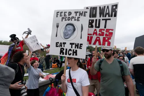 ▲民眾舉著「住手！」、「馬斯克寄生蟲」等標語抗議示威。（圖／美聯社／達志影像）