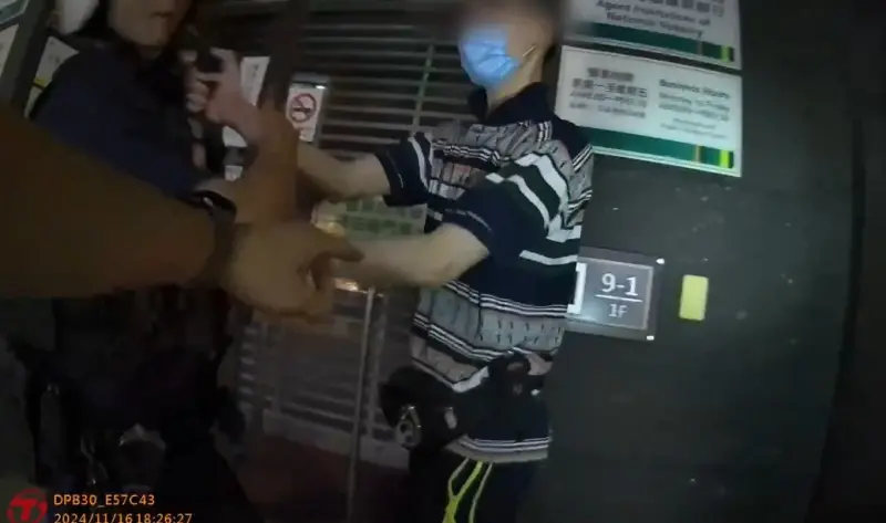 ▲林姓男子堵住金融機構的ATM大門口，持雨傘阻擋他人使用ATM，員警趕赴現場依法盤查，林男卻持打火機襲警。（圖／翻攝畫面）