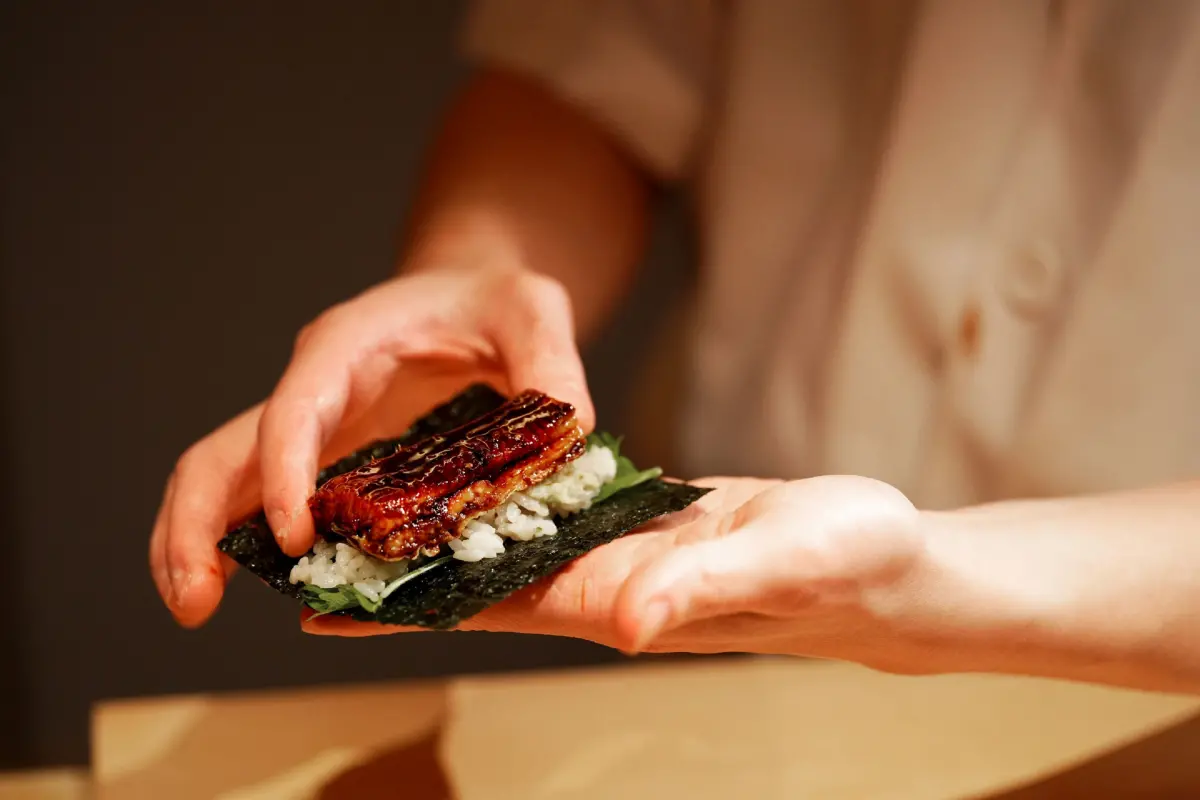 ▲台北喜來登飯店內「すし桃SUSHI MOMO」迎來兩周年慶，整個四月份兩人以上同行即贈平日午餐招待券，用此券可享四人同行、一人免費，圖為餐廳招牌菜「蒲燒鰻魚手卷」。（圖／台北喜來登提供）