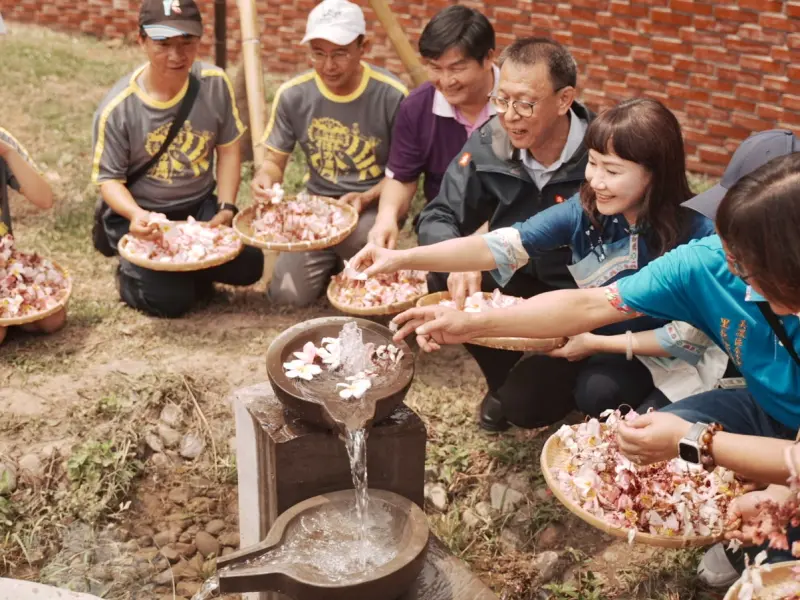 ▲大家在博士泉旁灑下花瓣象徵對湧泉的尊重與祝福。（圖／高市府客委會提供）