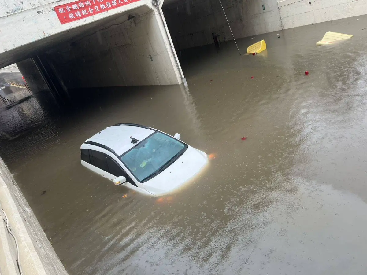 ▲桃園上午下大暴雨，平鎮區環南路地下道淹水，一輛白色小客車行經，遇水拋錨卡在地下道，差點滅頂。（圖／警方提供）