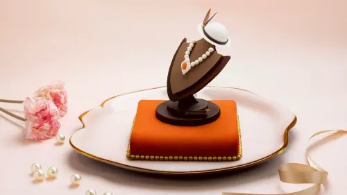 ▲ 「珍藏」蛋糕外型宛如一件仕女珠寶陳列，珍珠項鍊環繞胸針巧克力墜飾，搭配優雅仕女帽，向母親獻上最動人的祝福。（圖／高雄日航酒店提供）