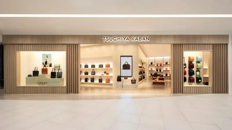 ▲入口形象_TSUCHIYA KABAN 土屋鞄製造所 LaLaport 南港店的店裝以溫潤的木質元素為基礎，外觀採用垂直陣列設計，巧妙構築出沉靜高雅的氛圍。（圖／品牌提供）