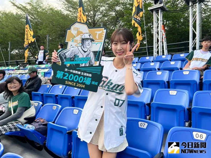 ▲台鋼雄鷹啦啦隊Wing Stars韓籍人氣團員安芝儇現身新莊球場，並舉著總教練洪一中2000場執教的立牌。（圖／記者陳云茹攝）