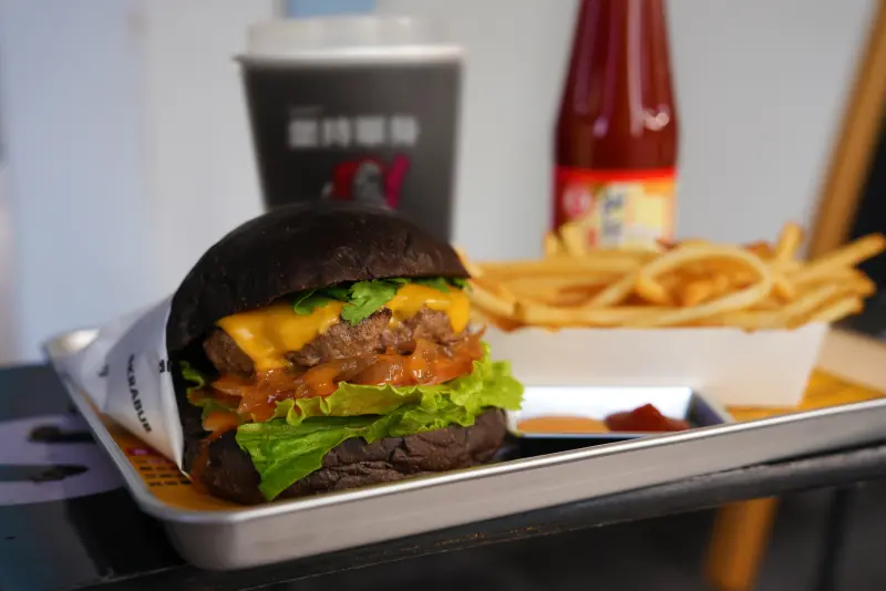 ▲金蘭食品與黑膠漢堡攜手推出限定聯名漢堡——「黑金甜辣堡」。（圖／金蘭食品提供）