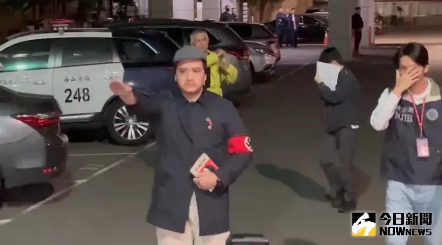 ▲罷免李坤城領銜人宋建樑手臂戴著象徵納粹的「卐」字臂章，手比納粹敬禮手勢，拿著希特勒著作「我的奮鬥」進入偵查大樓引起爭議。（圖／記者嚴俊強攝）
