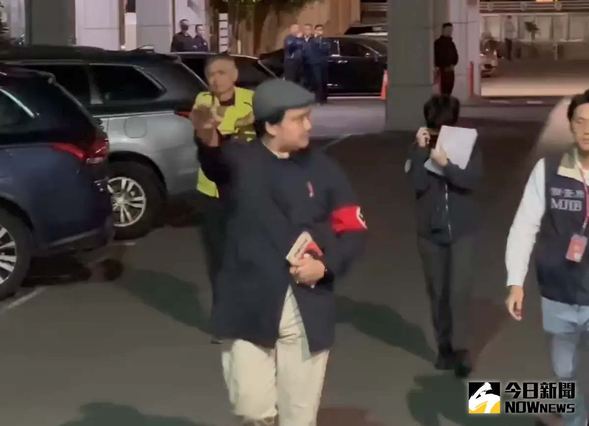 ▲罷免李坤城領銜人宋建樑手臂戴著象徵納粹的「卐」字臂章，手比納粹敬禮手勢，拿著希特勒著作「我的奮鬥」進入偵查大樓引起爭議。（圖／記者嚴俊強攝）