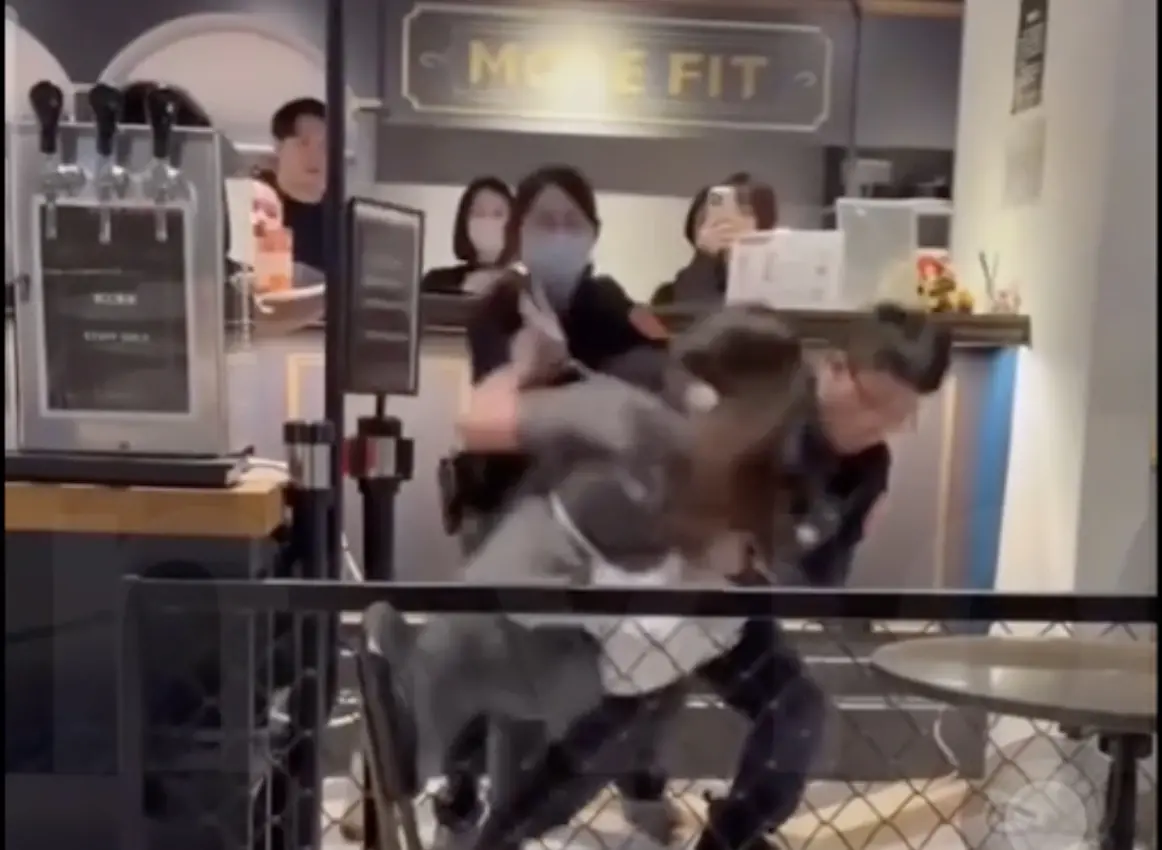 ▲身穿灰衣遭警大外割制伏的女子，因跑到總店找老闆理論討「非志願離職證明」不成，在店裡大吵大鬧，被店家提告侵入民宅，員警依法逮捕。（圖／翻攝爆料公社）