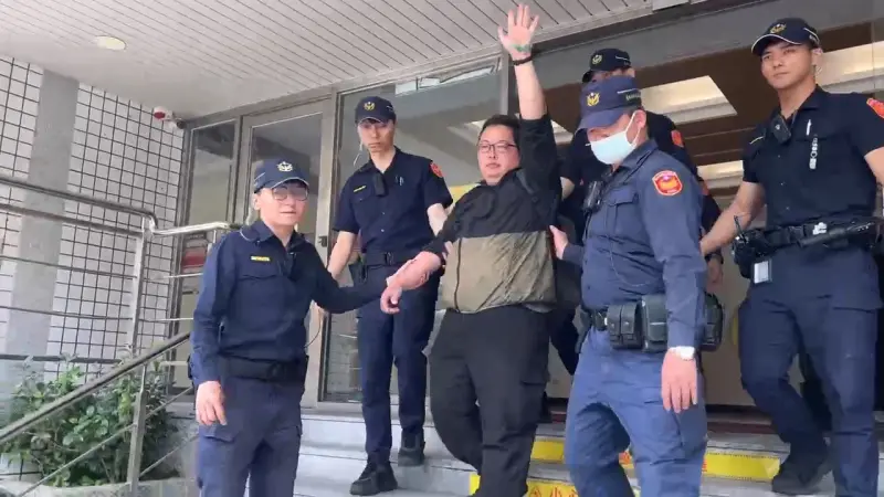 ▲抗議常客田山盛國落網上警車前,高舉左手秀出手掌上的綠色油漆。(圖/翻攝畫面)