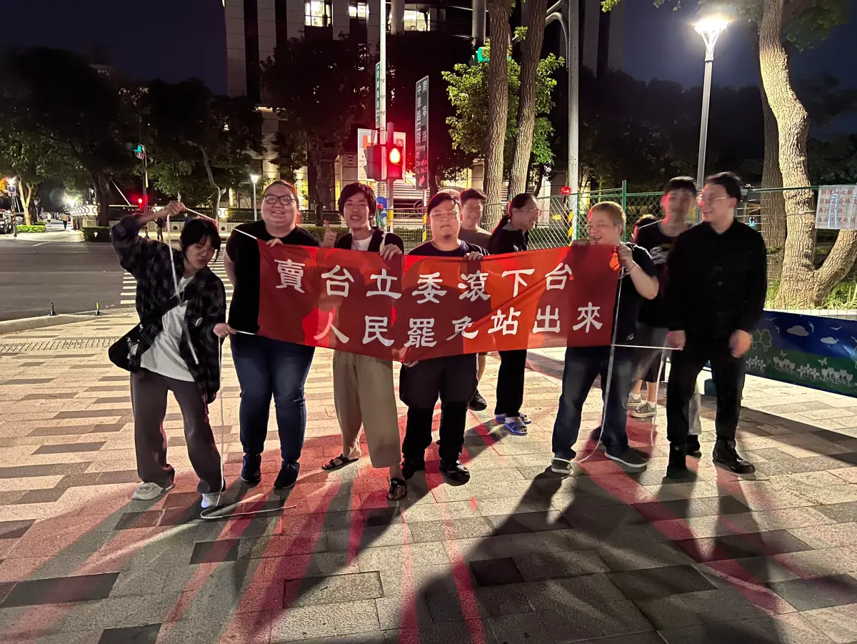 ▲支持罷免國民黨立委的年輕人，晚上到北檢前高舉布條，喊話「賣台立委滾下台、人民罷免站出來」，挑釁意味濃厚。（圖／記者徐敏娟攝）