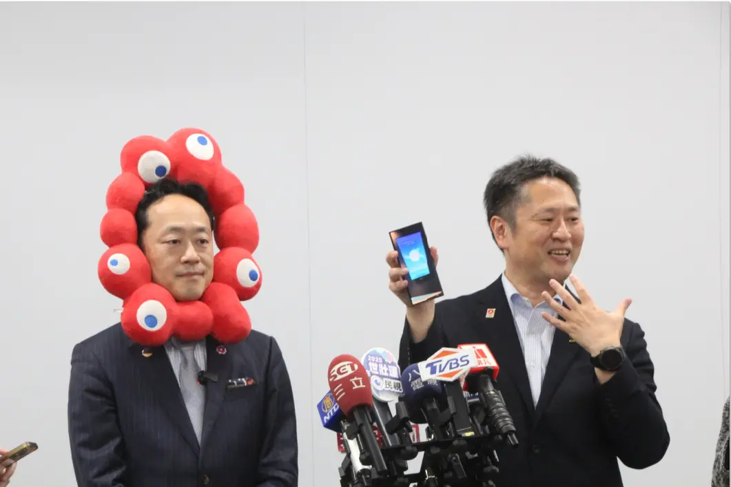 ▲井村悟朗（圖右）在平日再度拜訪Tech World館，合計目前看到20個展覽館，認為Tech World館是他心目中的第一名，忍不住拿出手機開始分享自己所記錄的畫面，更很開心拿到珍珠奶茶的小禮物。（圖／記者鍾泓良攝影）