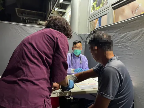 ▲屏東榮民總醫院主任陳弘哲為街友問診量血壓。（圖／屏東縣府提供）