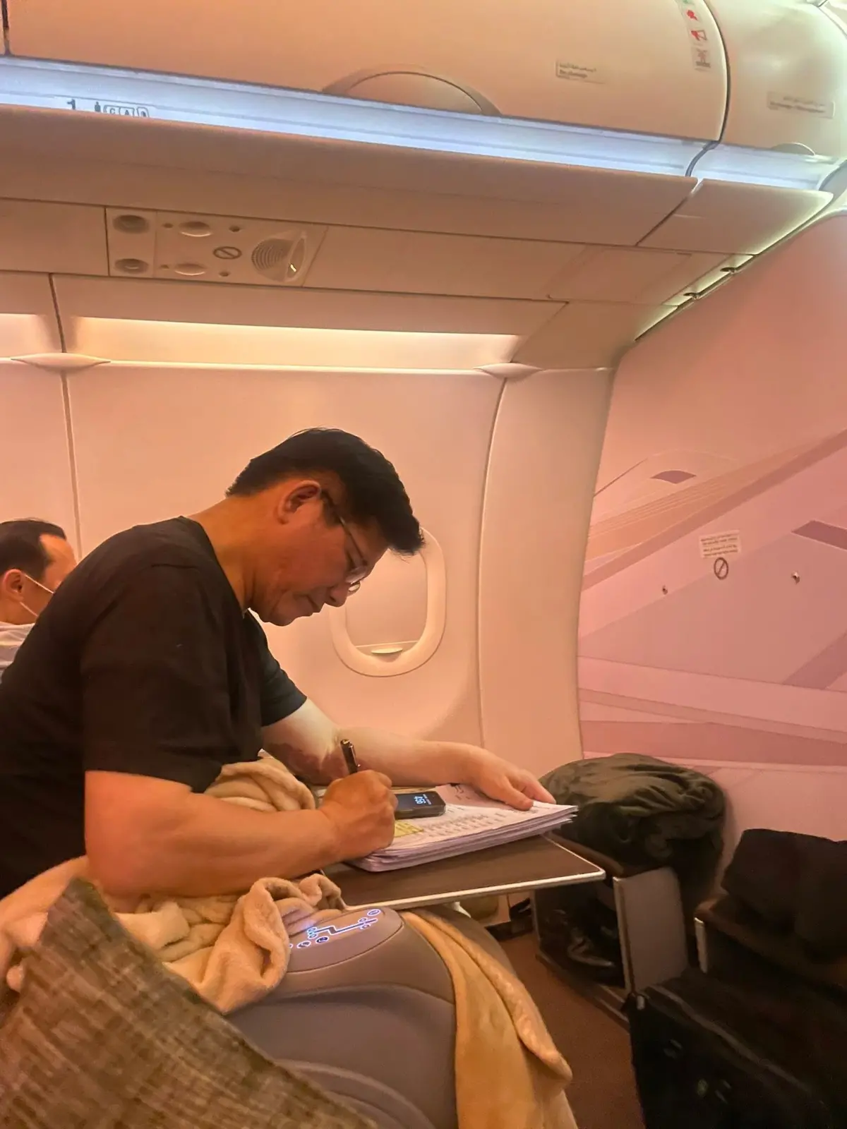 ▲衛福部次長呂建德陪同林佳龍訪非，他PO出林佳龍在機上仍低頭認真工作的模樣。（圖 /翻攝呂建德臉書）