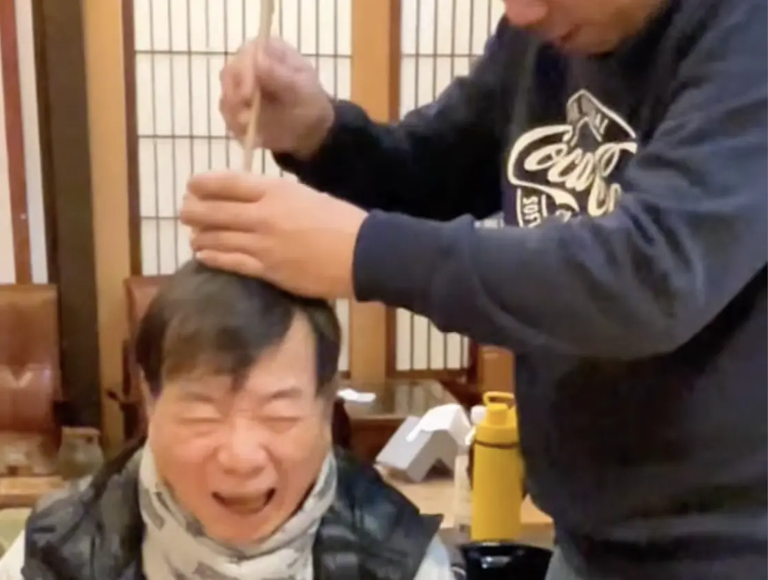 ▲廖峻在短片中頭頂著碗、旁人用筷子不停敲著碗，他露出驚訝的表情，雖然後來在片中坦言「不會痛」，卻讓他兒子廖錦德發文表達不滿，對此經紀人蔣少稱是借位，不會讓廖峻真的被敲頭，也請廖錦德把自己的家事處理好。（圖／摘自ogsliao IG）