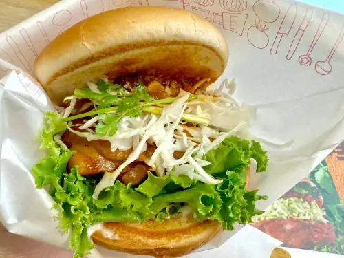 ▲摩斯「香菜咖哩烤雞堡」熱呼呼拿到手，馬上確認香菜量。（圖／記者蕭涵云攝）