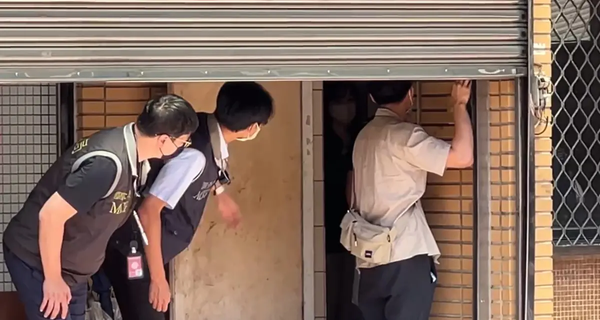 ▲檢調人員拉下國民黨台中市黨部鐵門進行搜索。（圖／讀者提供，2025.05.02）
