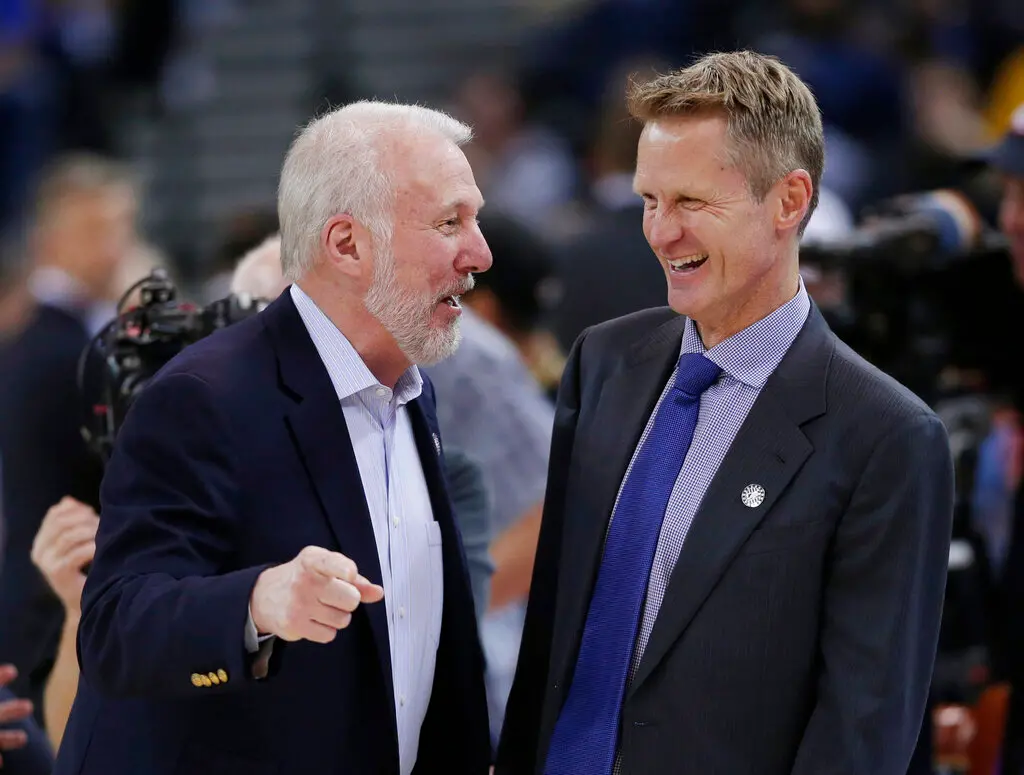 ▲聖安東尼奧馬刺傳奇總教練Gregg Popovich於昨日正式宣布卸下主帥職務，結束長達近30年的執教生涯。他在NBA有很多徒弟們，其中兩位正是目前在進行系列賽的金州勇士隊總教練Steve Kerr和休士頓火箭隊總教練Ime Udoka，兩人賽前都穿上Popovich圖像的T恤，向恩師致敬。（圖／美聯社／達志影像）