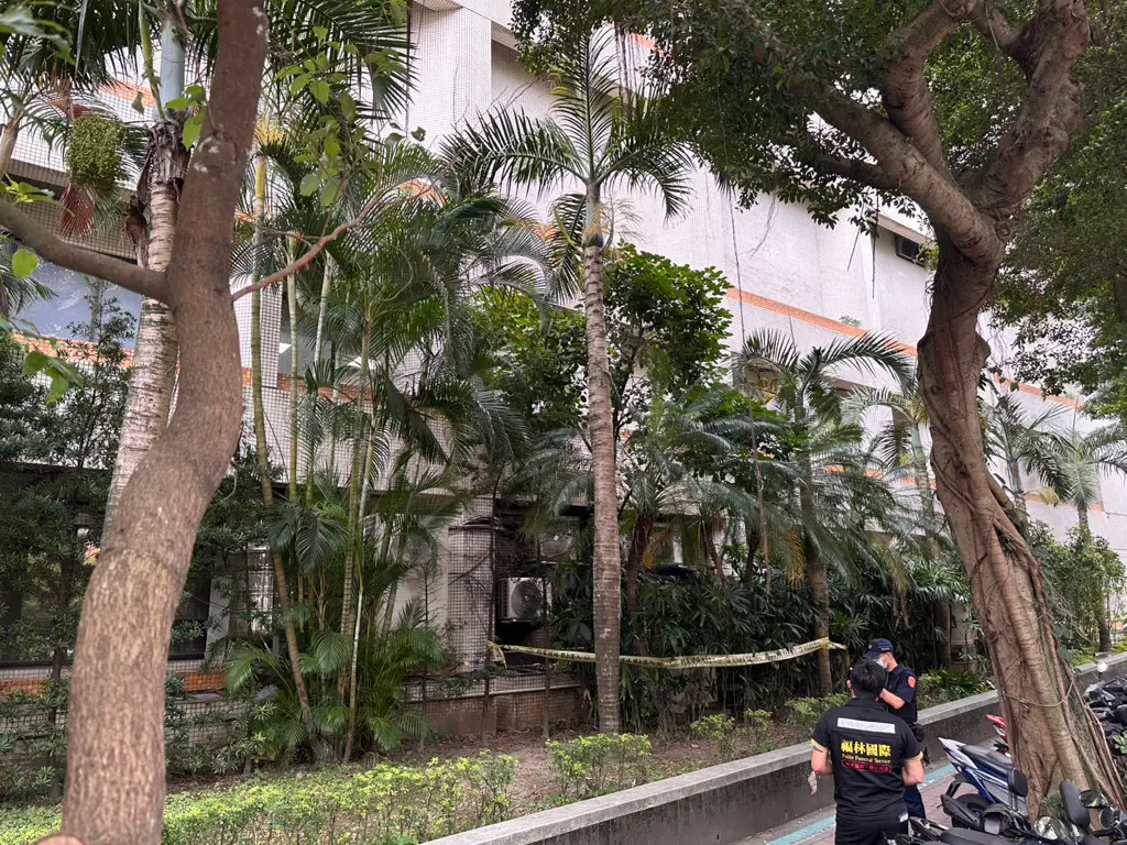 ▲警方在樹叢內的冷氣室外機上發現一具男屍，立刻拉起封鎖線進行調查。（圖／翻攝畫面）