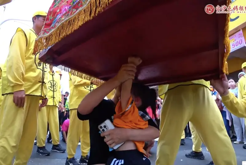 ▲白沙屯媽祖今早行經彰化秀水鄉彰水路時，一名媽媽抱著還不會說話的4歲女兒跪在路邊，眼含熱淚頻頻叩首，獲得了媽祖的加持。（圖／翻攝自白沙屯媽祖網路電視台YT）