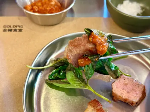 ▲「熟成帶骨豬五花」以烘烤過的甜羅勒包起，好吃必試。（圖／記者蕭涵云攝）