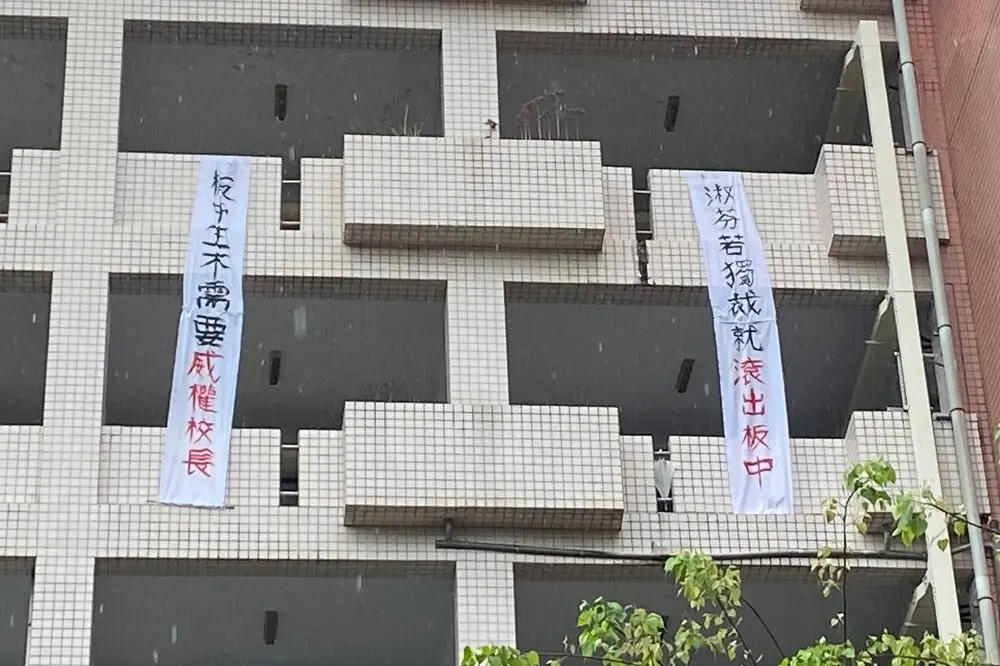 ▲板中校慶暨園遊會，學生在教室大樓外牆高掛著抗議布條。（圖／翻攝靠北板中2.0臉書社團）