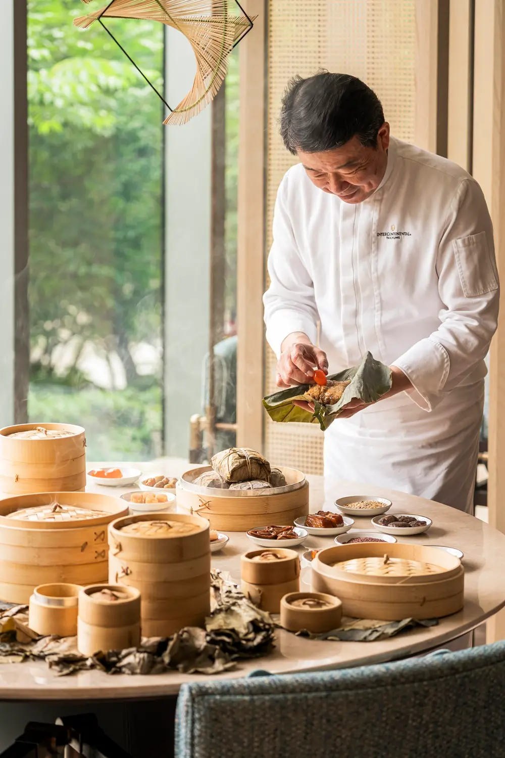 ▲明娟樓主廚吳錫卿帶領團隊掌控逾8小時的低溫慢蒸，讓葉香沁入米芯，鹹香交融。（圖／業者提供）