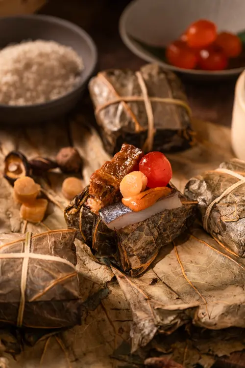 ▲明娟樓端出的海膽飛魚裹蒸粽，以七穀米為基底，搭配海膽、飛魚乾、干貝與鹹蛋黃，山海交融之作。（圖／業者提供）