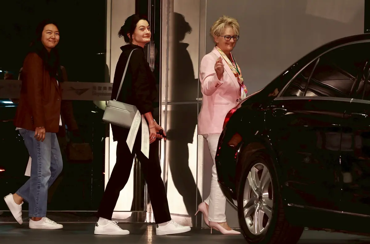 ▲Lori（圖右）也與現場媒體揮手致意，但直到所有車輛離去，黃仁勳本人都尚未抵台。（圖／記者葉政勳攝影）