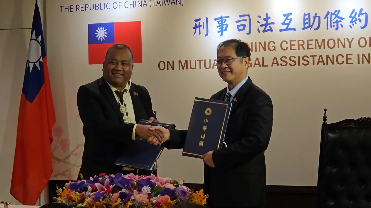 ▲法務部長鄭銘謙（右）與馬紹爾群島共和國司法部長查克拉（左）簽訂司法互助條約後握手合影。（圖／記者劉松霖攝）