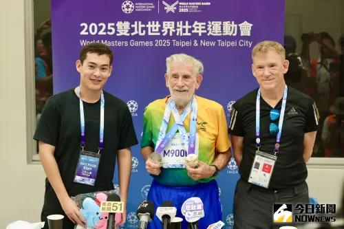 ▲「昆凌爺爺」Quinlivan Laurence James在田徑項目大展身手，他在早上在標槍賽事奪金，之後100公尺跑步則是拿下銀牌，收穫一金一銀的成績。受訪時孫子和兒子陪伴其左右。（圖／記者朱永強攝）