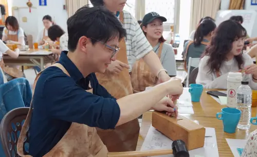 ▲青年局長林楷軒親自手作荔枝木餐具,體驗農業結合文創的在地循環經濟。(圖/高市府青年局提供) ▲青年局長林楷軒親自手作荔枝木餐具,體驗農業結合文創的在地循環經濟。(圖/高市府青年局提供)