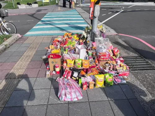 三峽北大國小昨發生3死重大車禍,有2學生不幸身亡,事故地點放滿許多零時、巧克力,哀悼死者。(圖/記者徐敏娟攝) ▲三峽北大國小昨發生3死重大車禍,有2學生不幸身亡,事故地點放滿許多零時、巧克力,哀悼死者。(圖/記者徐敏娟攝)